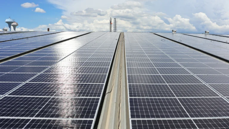 A imagem mostra painéis solares fotovoltaicos instalados no telhado de uma empresa do Grupo A, representando a adoção da energia solar como fonte de energia limpa e renovável.